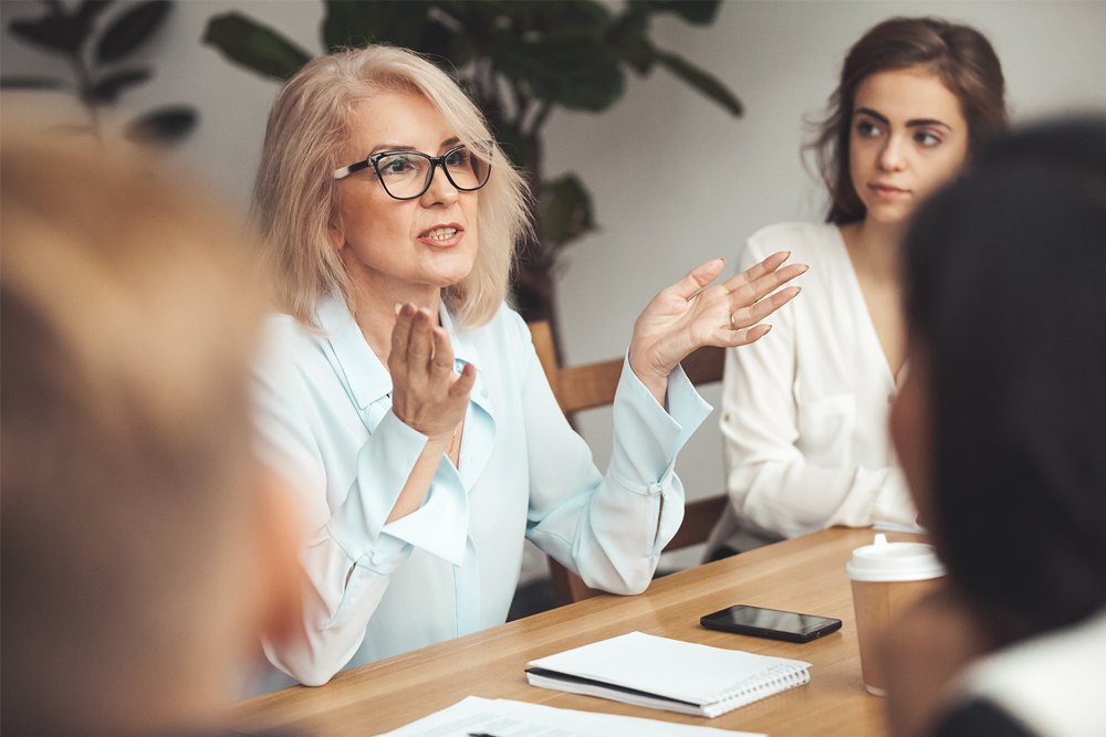 Female Lawyer talking to a clients around a conference table